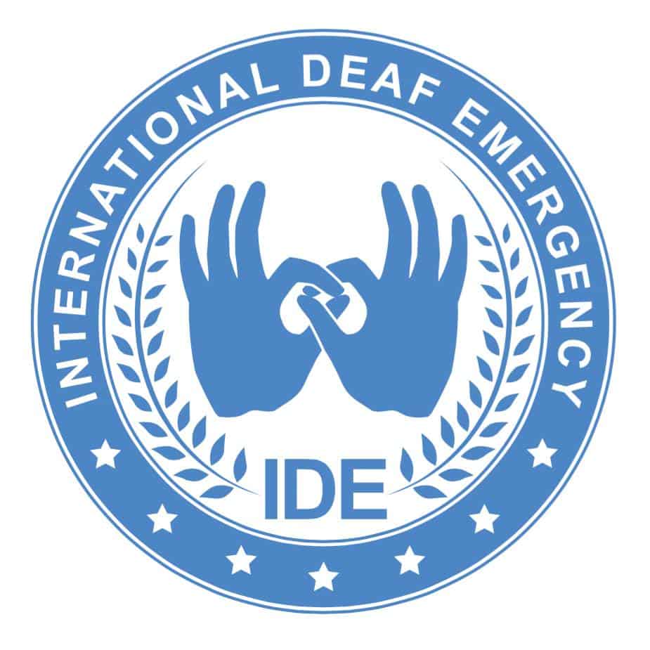 Blue and white logo with two hands signing, laurel branches, and the text "INTERNATIONAL DEAF EMERGENCY IDE" within a circular border with stars.