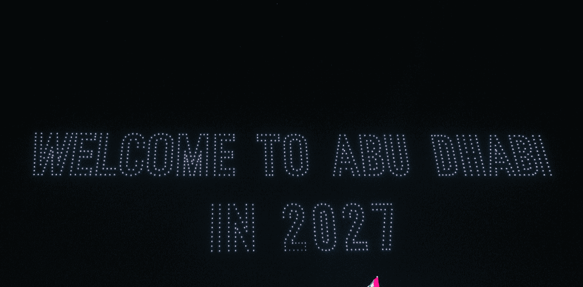 Text in lights reads "Welcome to Abu Dhabi in 2027" against a dark background.