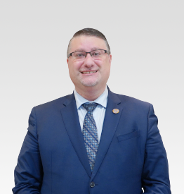 A man in a suit and tie standing in front of a white background