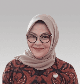 Person wearing glasses and a patterned jacket, smiling in front of a neutral background.