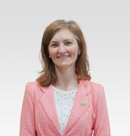 A woman in a pink jacket and white shirt