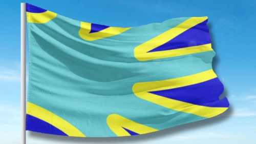 A flag with a teal background and yellow and blue overlapping shapes, waving against a blue sky.