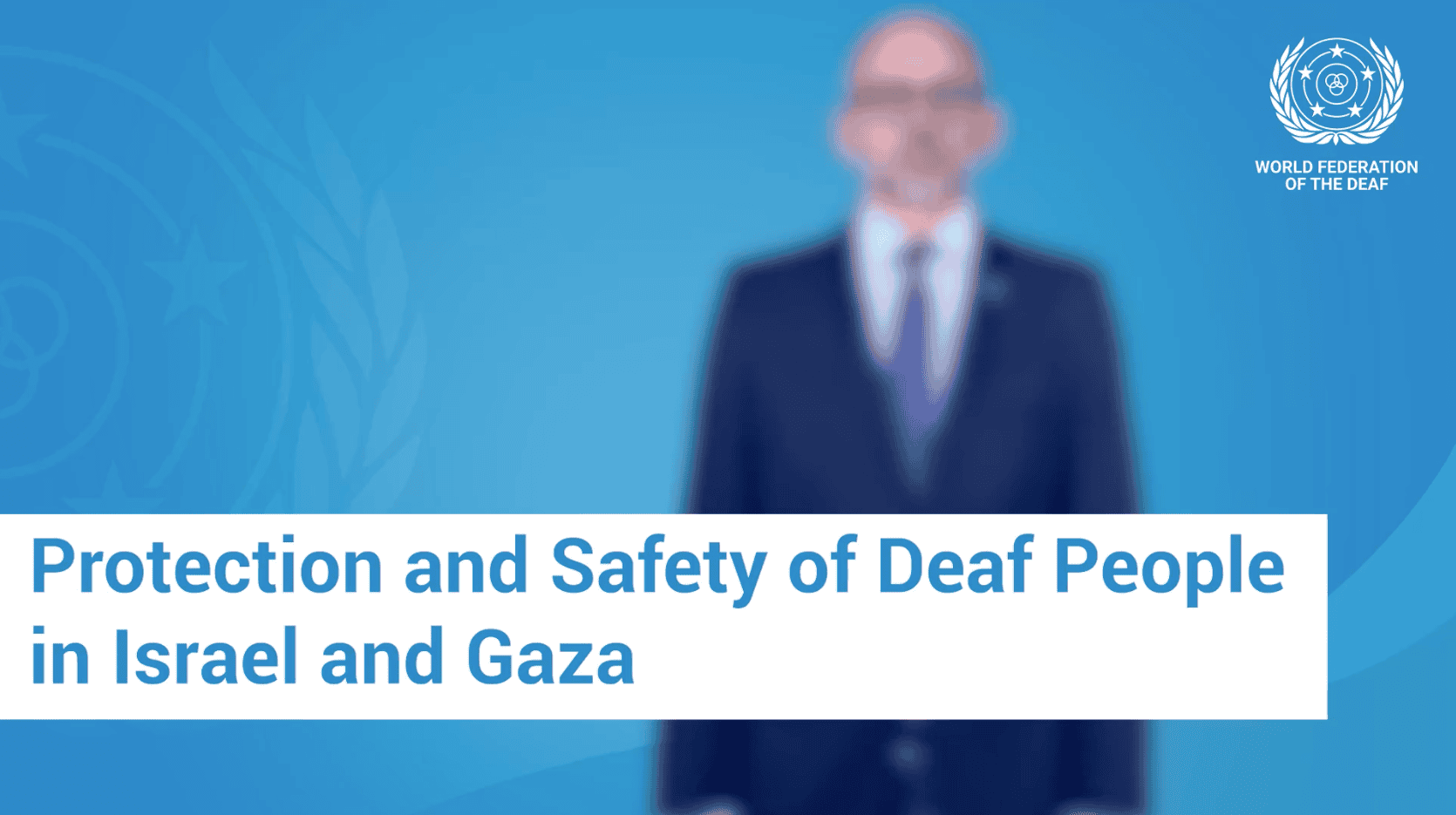 A blurred man in a suit stands before a blue World Federation of the Deaf logo background, with text: "Protection and Safety of Deaf People in Israel and Gaza.